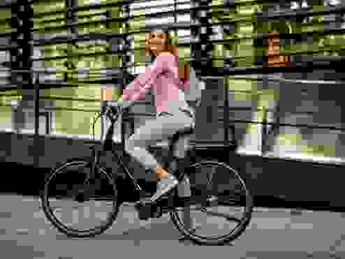 Women in a pink top riding a e-bike
